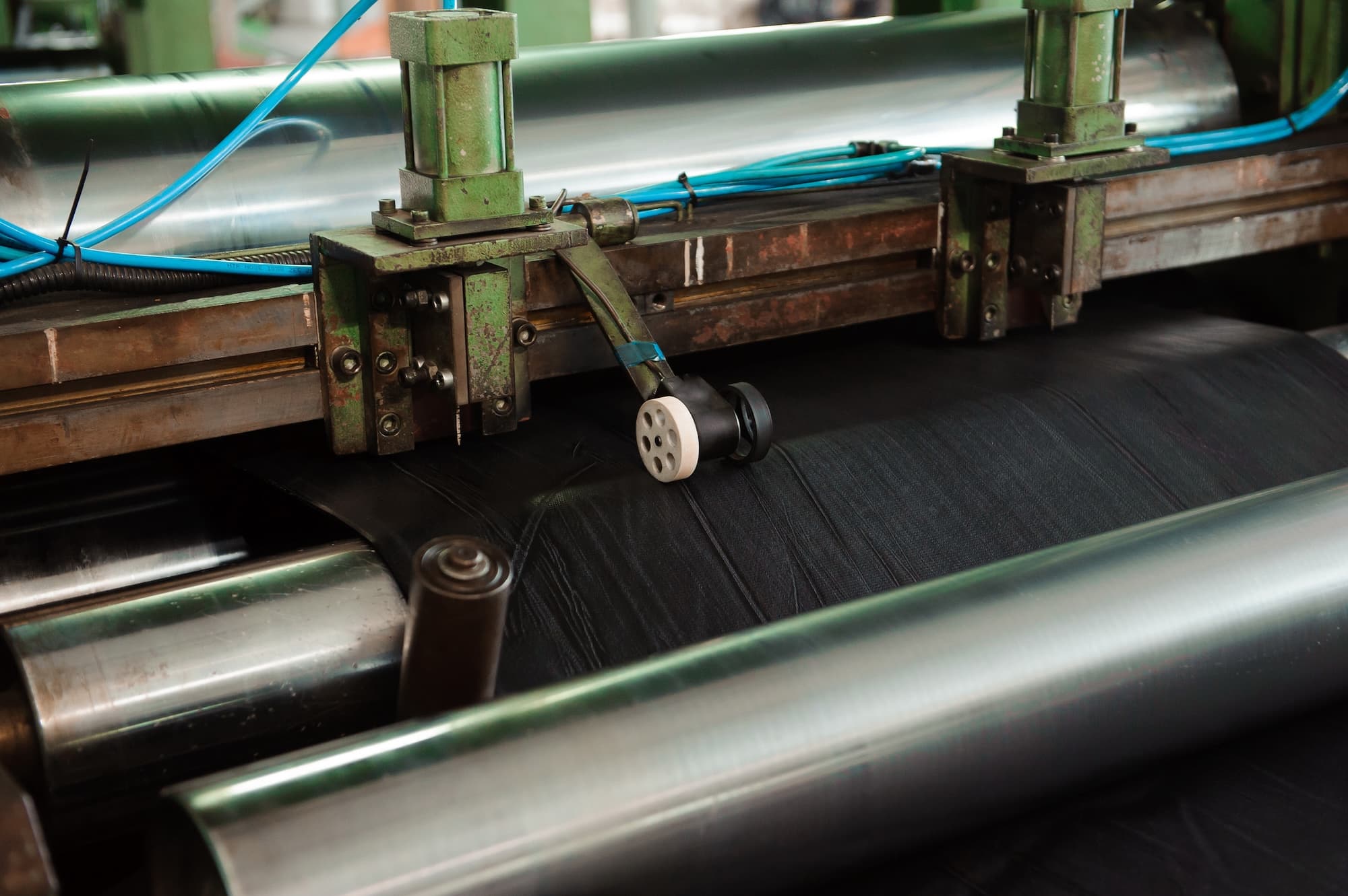 industrial calendering line rolling rubber through precision rollers during manufacturing process