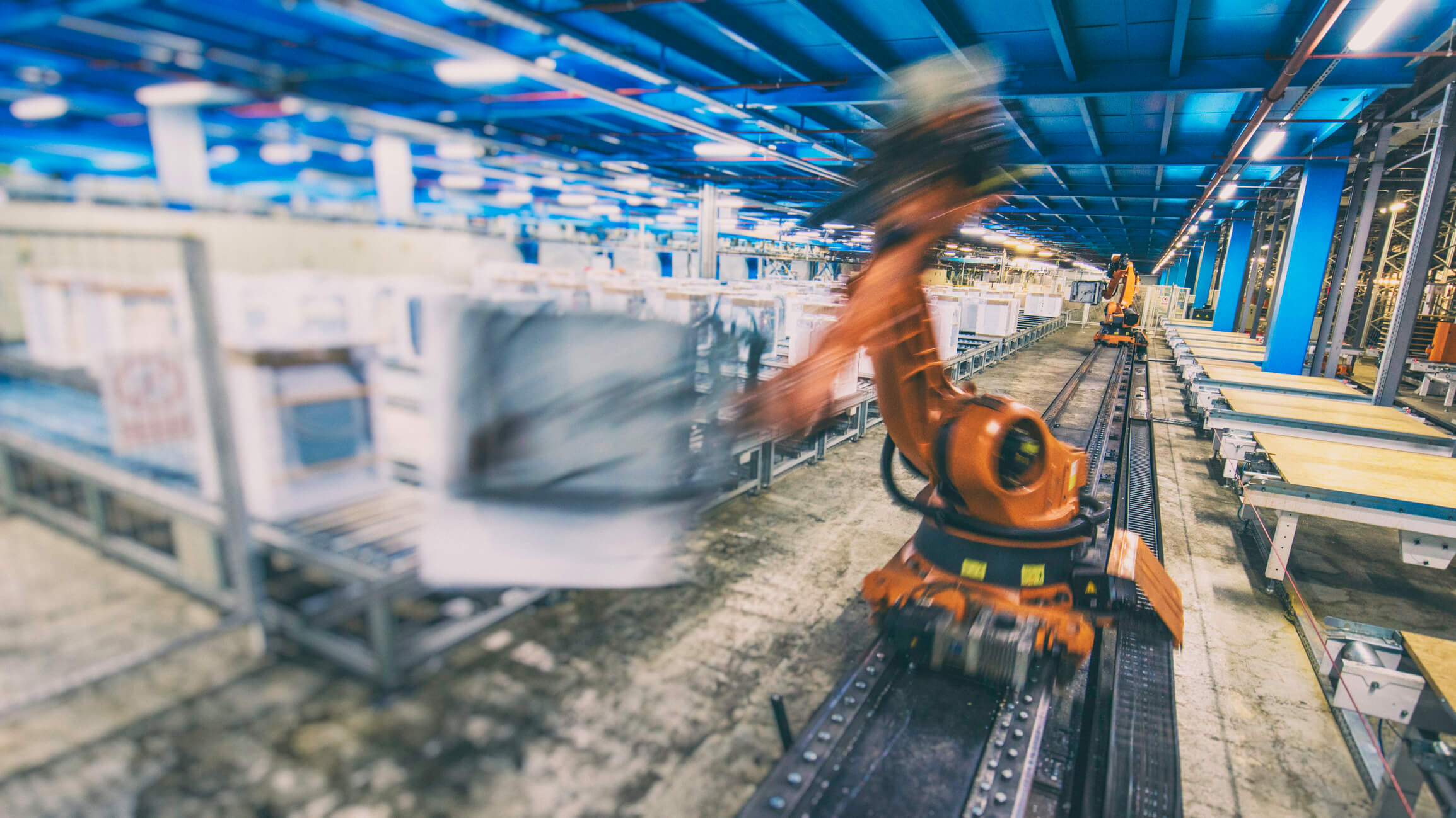 Image of industrial robot in motion inside appliance manufacturing plant