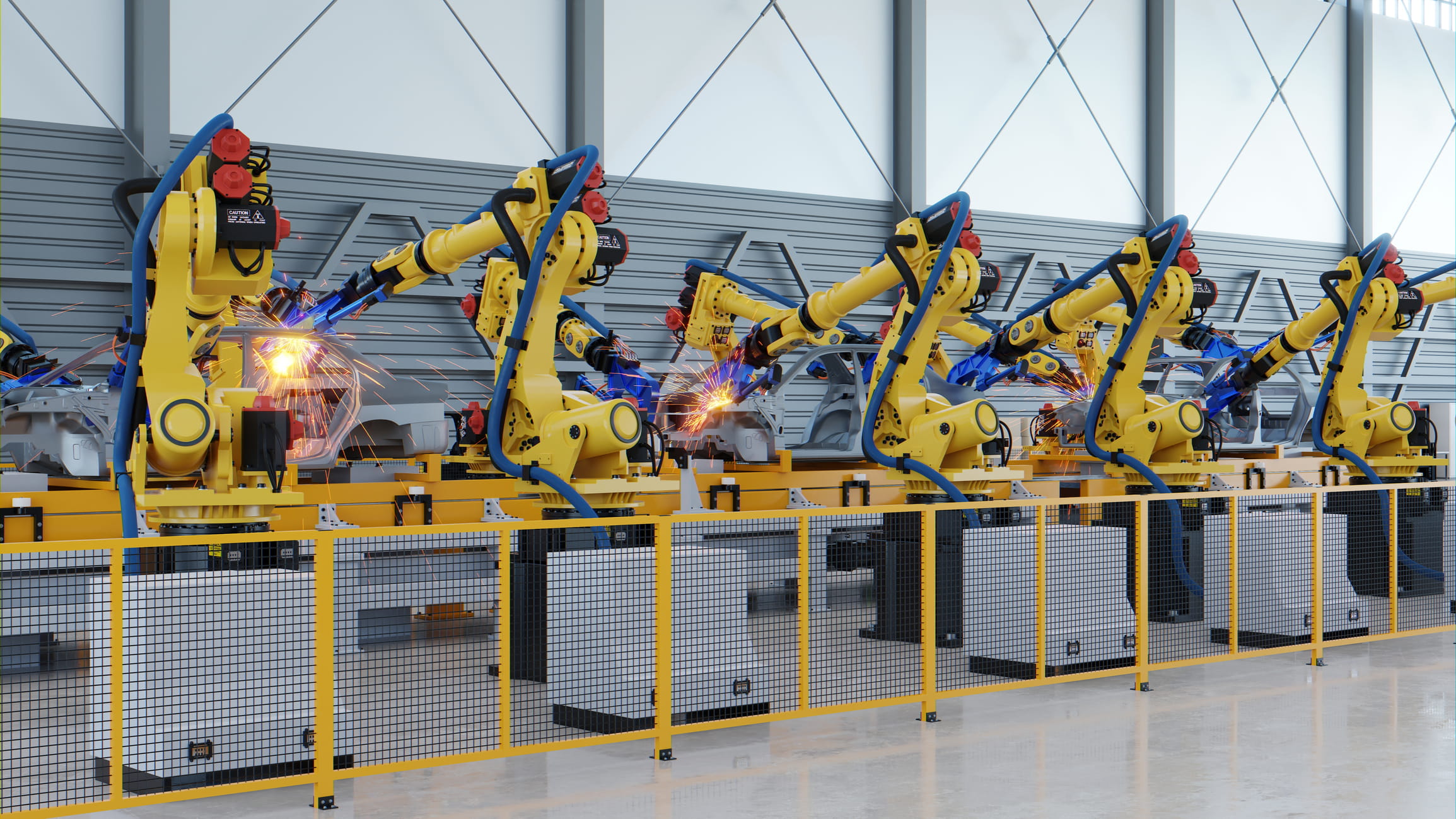 automated automotive manufacturing showing yellow industrial robotic arms around on a factory floor